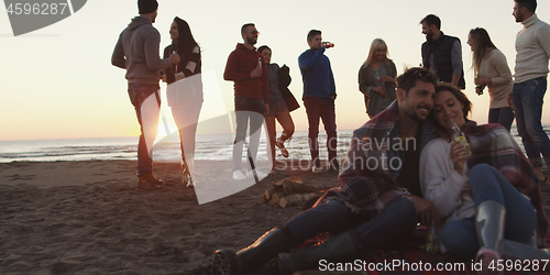 Image of Friends having fun at beach on autumn day