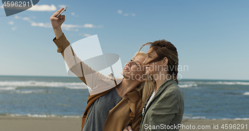 Image of Girls having time and taking selfie on a beach