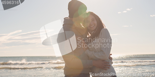 Image of Couple having fun on beautiful autumn day at beach