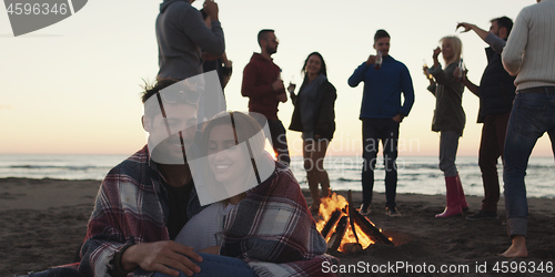 Image of Friends having fun at beach on autumn day