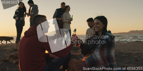 Image of Friends having fun at beach on autumn day