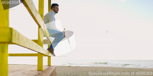 Image of man drinking beer at the beach