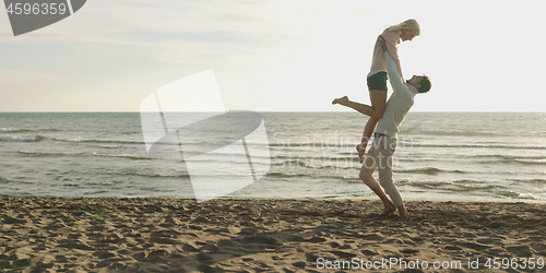 Image of Loving young couple on a beach at autumn on sunny day