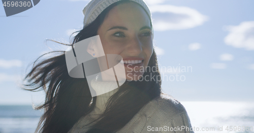 Image of Girl In Autumn Clothes Smiling on beach