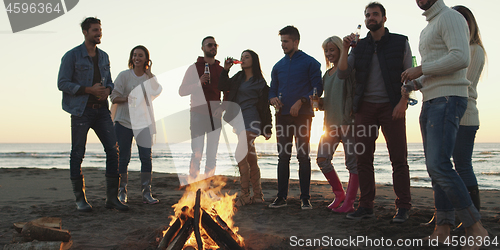 Image of Friends having fun at beach on autumn day