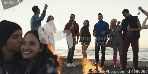 Image of Friends having fun at beach on autumn day