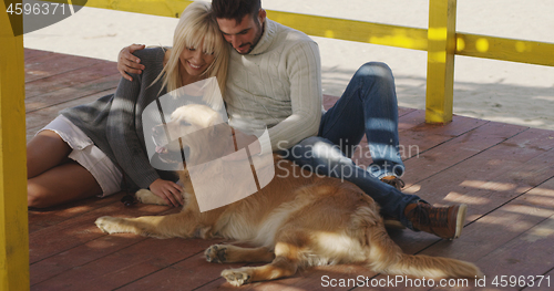 Image of Couple with dog enjoying time on beach