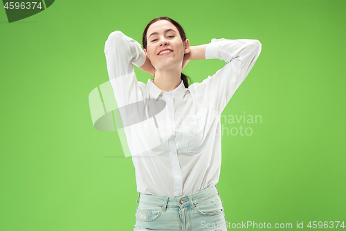 Image of The happy business woman standing and smiling against green background.