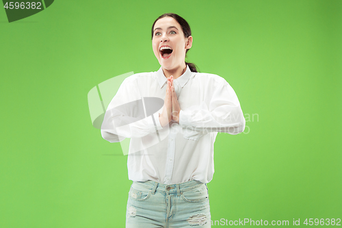Image of Beautiful woman looking suprised isolated on green