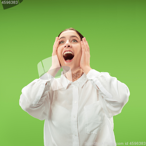 Image of Beautiful woman looking suprised isolated on green