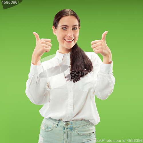 Image of The happy business woman standing and smiling against green background.