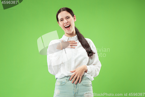 Image of The happy business woman standing and smiling against green background.