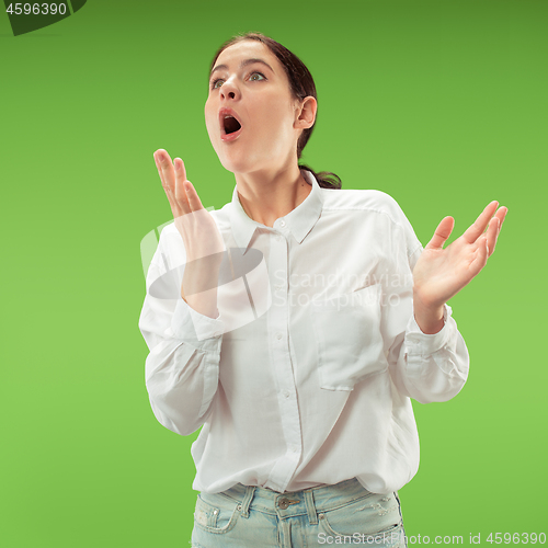 Image of Beautiful woman looking suprised isolated on green