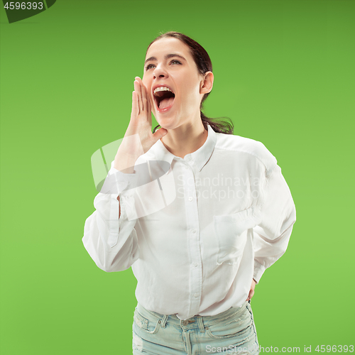 Image of Isolated on green young casual woman shouting at studio