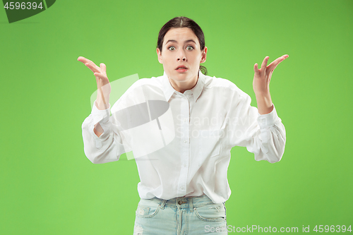 Image of Beautiful woman looking suprised isolated on green