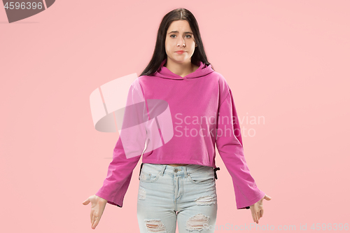 Image of Beautiful woman looking suprised and bewildered isolated on pink