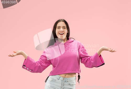 Image of The happy business woman standing and smiling against pink background.