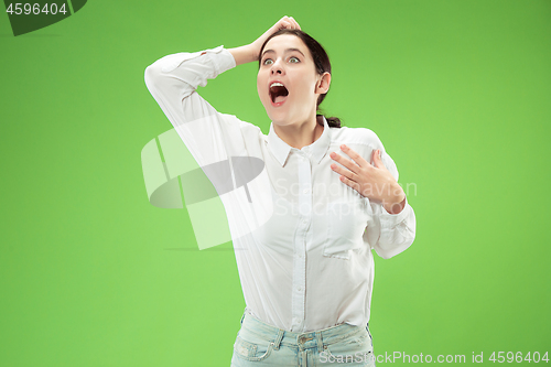 Image of Beautiful woman looking suprised isolated on green