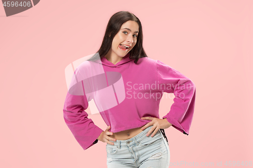 Image of The happy business woman standing and smiling against pink background.