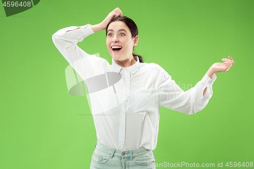 Image of Beautiful woman looking suprised isolated on green