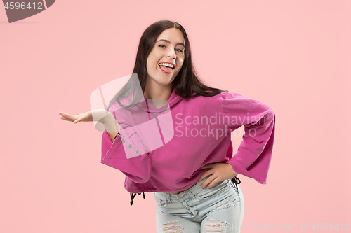 Image of The happy business woman standing and smiling against pink background.