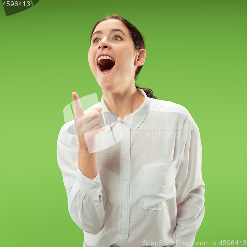 Image of Beautiful woman looking suprised isolated on green