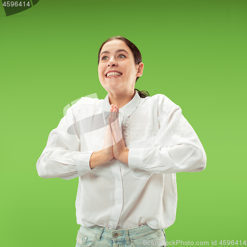 Image of Beautiful woman looking suprised isolated on green