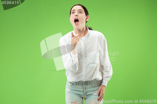 Image of Beautiful woman looking suprised isolated on green