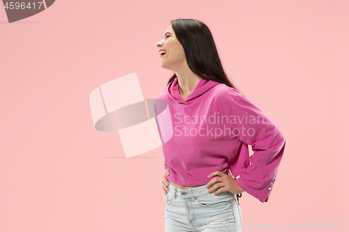 Image of The happy business woman standing and smiling against pink background.