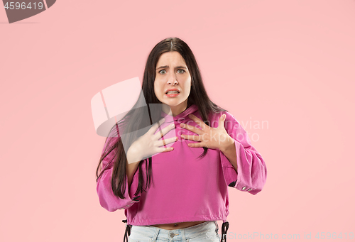 Image of Beautiful female half-length portrait isolated on pink studio backgroud. The young emotional surprised woman