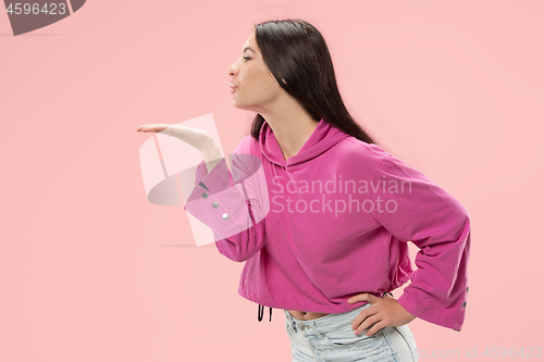 Image of Portrait of attractive cute girl with bright makeup with kiss isolated over pink background