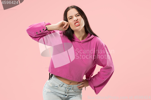 Image of Beautiful female half-length portrait isolated on pink studio backgroud. The young emotional surprised woman