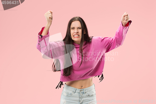 Image of Beautiful female half-length portrait isolated on pink studio backgroud. The young emotional surprised woman