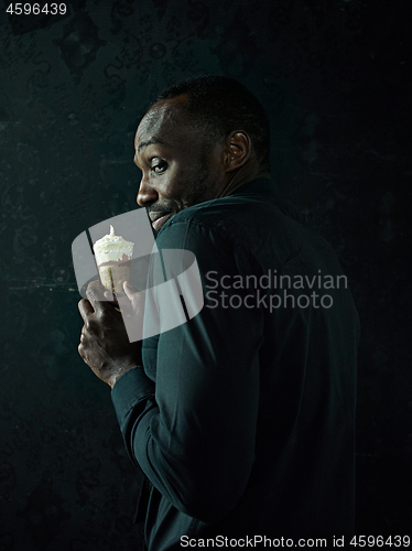 Image of Portrait of afro american man holding ice cream