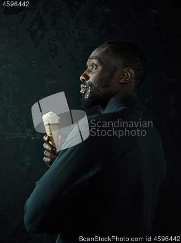 Image of Portrait of afro american man holding ice cream