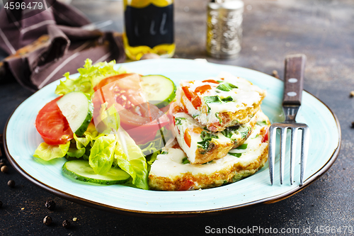 Image of omelette with vegetables on white plate