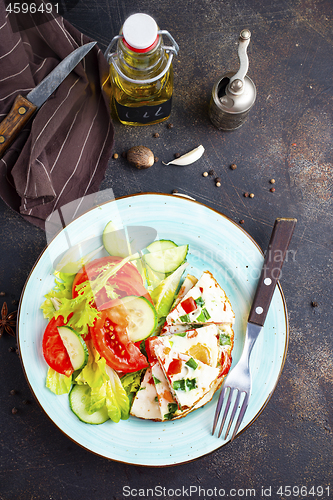 Image of omelette with vegetables on white plate