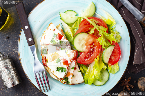 Image of omelette with vegetables on white plate