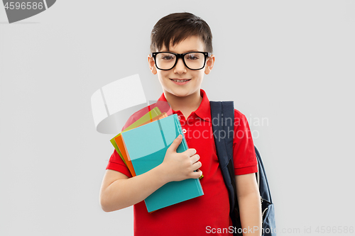 Image of smiling schoolboy in glasses with books and bag
