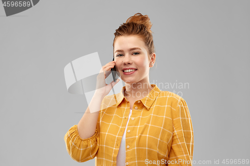 Image of smiling redhead teenage girl calling on smartphone