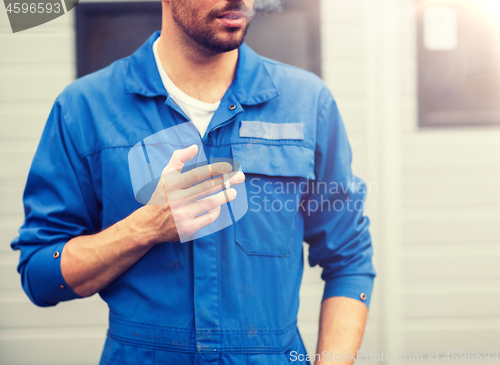 Image of close up of auto mechanic smoking cigarette