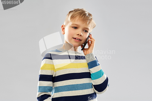 Image of boy in striped pullover calling on smartphone