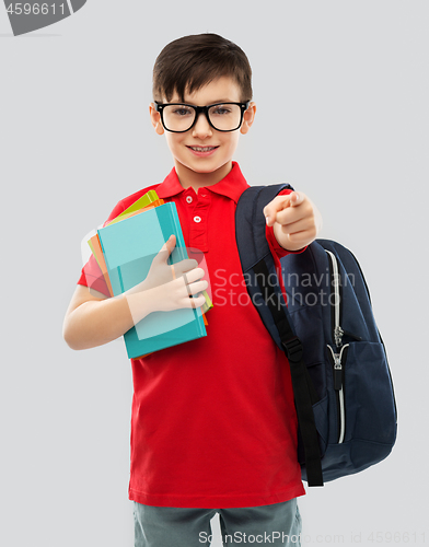 Image of smiling schoolboy in glasses with books and bag