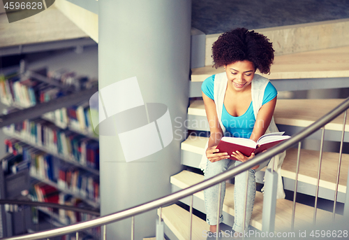 Image of african student girl reading book at library