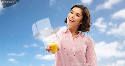 Image of happy young woman in pajama holding orange juice