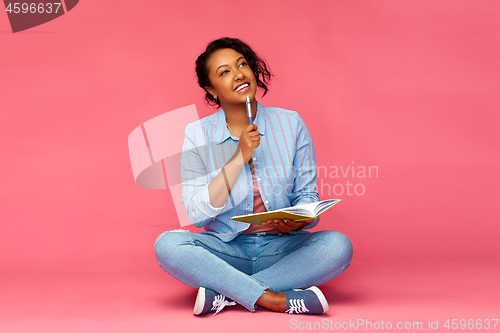 Image of student woman with diary or notebook thinking