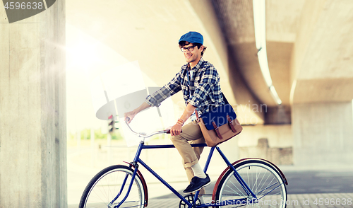 Image of happy hipster man with bag riding fixed gear bike