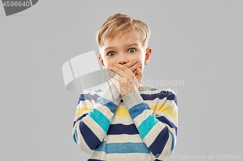 Image of shocked little boy closing his mouth by hands