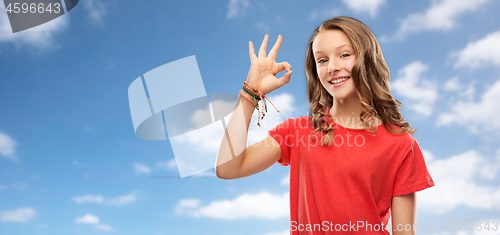 Image of smiling teenage girl in red t-shirt showing ok