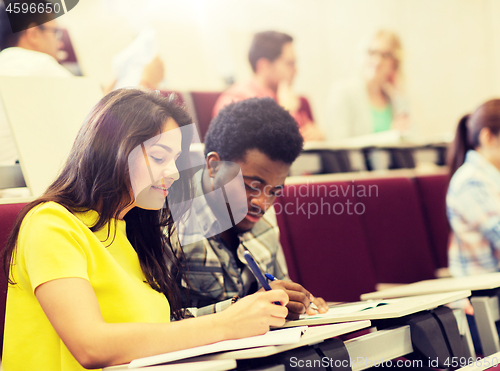 Image of group of students with notebooks in lecture hall